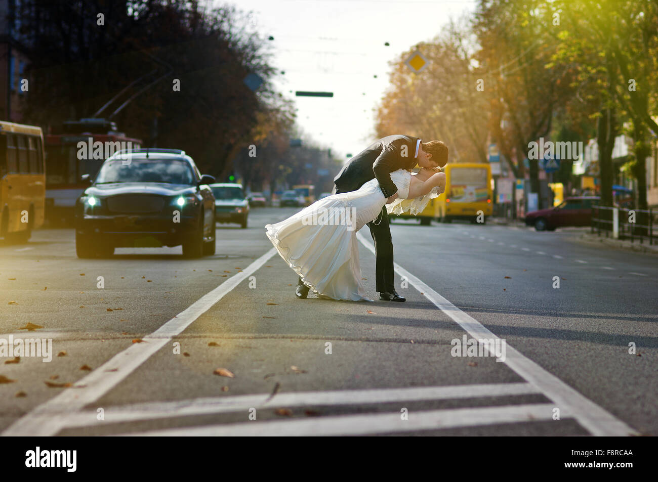 Kissing wedding couple in the middle of the road Stock Photo - Alamy