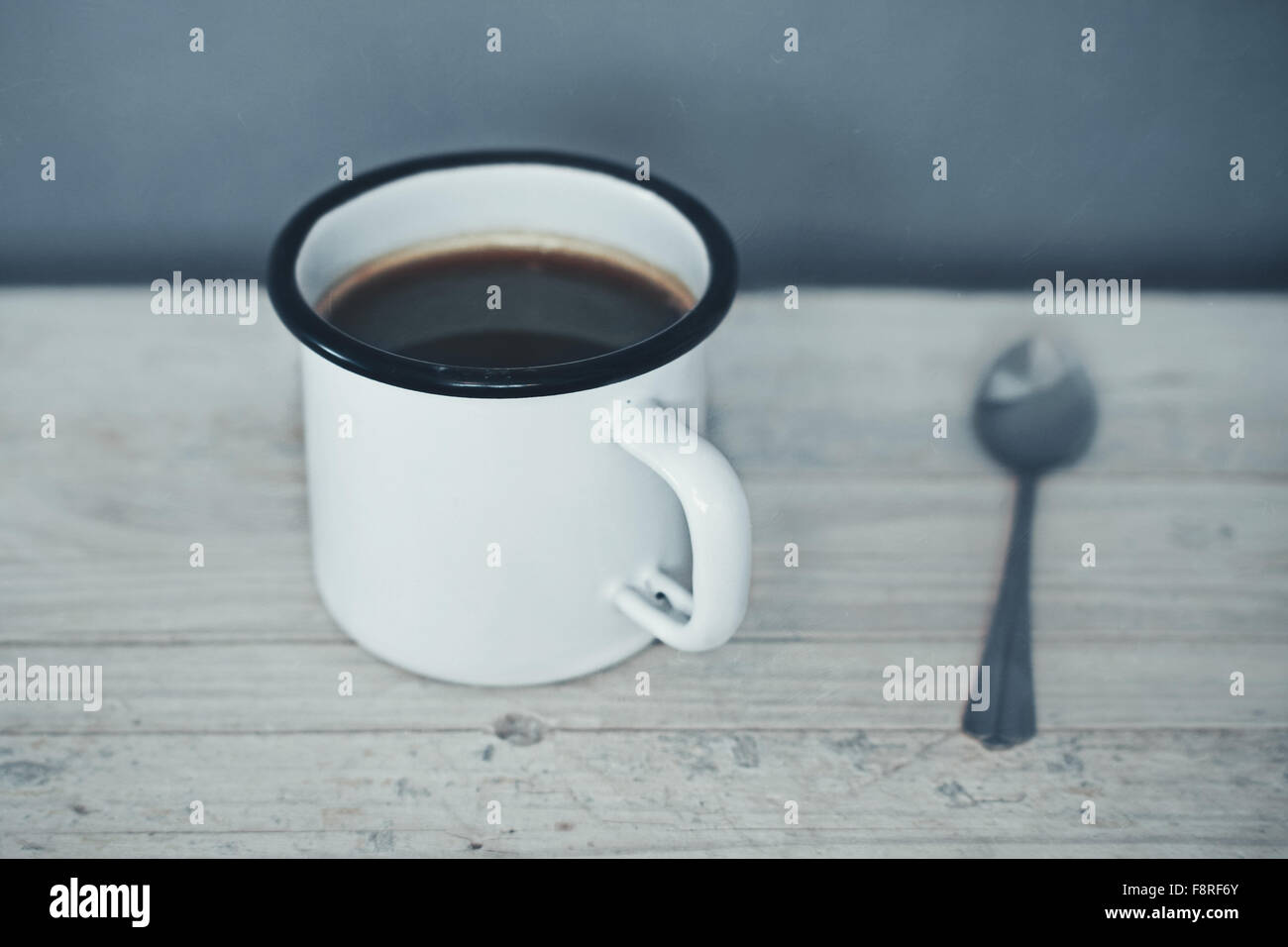 Mug of coffee and a spoon on a table Stock Photo