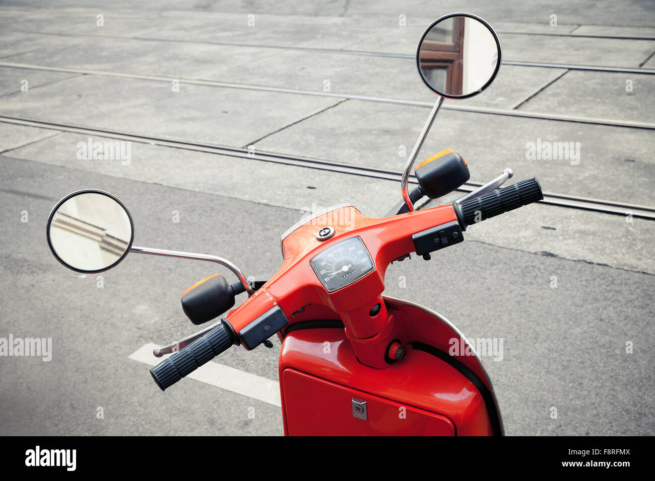 Red classical Italian scooter handlebar with speedometer and mirrors Stock Photo