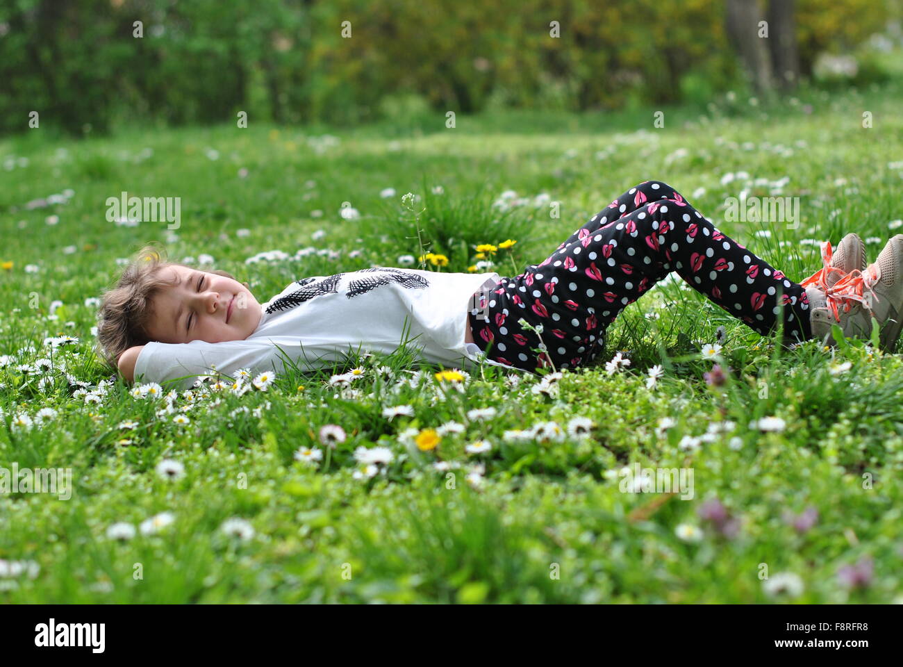 Girl lying on grass in springtime Stock Photo