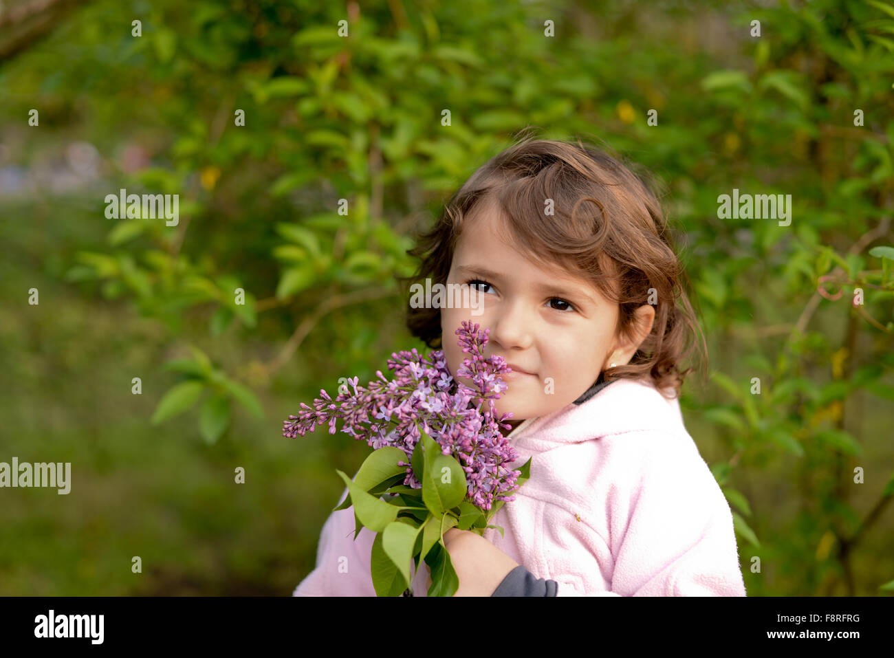 Portrait of a girl holding bouquet of lilac flowers Stock Photo