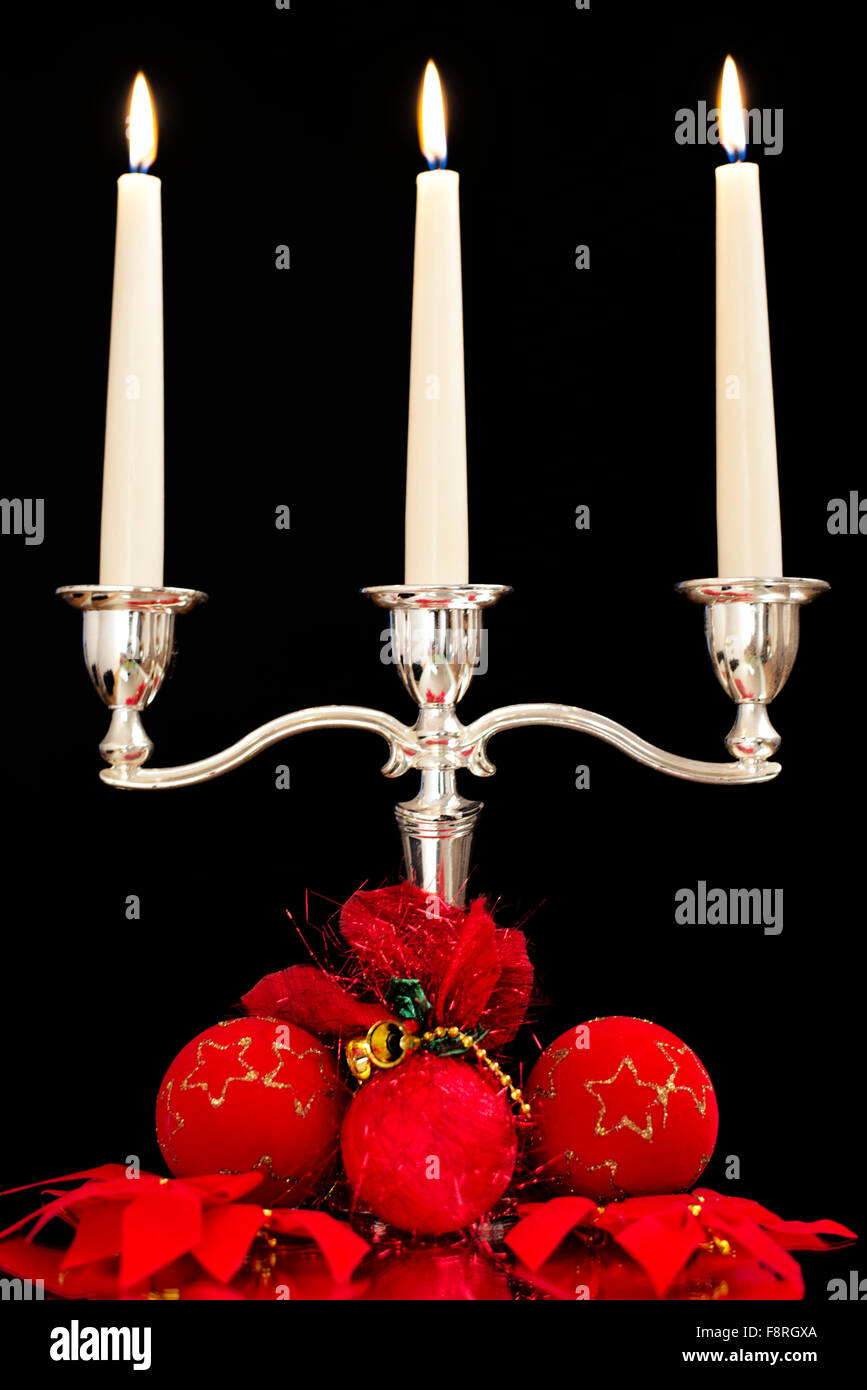 candlestick with three candles, red Christmas tree balls and bruises as Christmas and New Year decoration Stock Photo