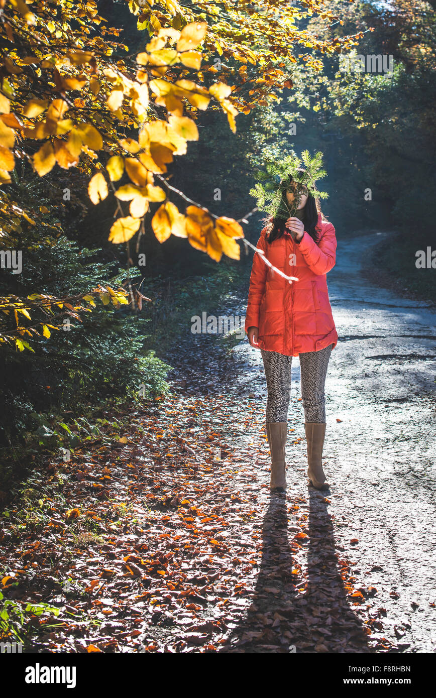 Woman hiding behind tree branch Stock Photo