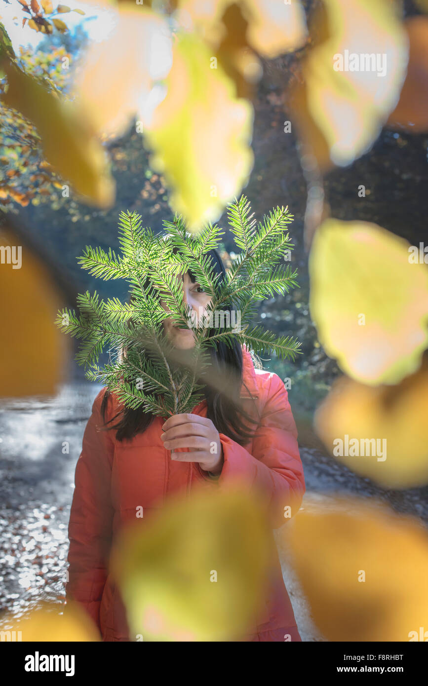 Woman holding fir tree branch in front of face Stock Photo