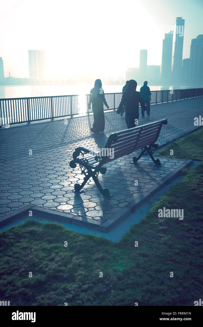 Arab woman taking a walk early in the morning in winter on the corniche. Stock Photo