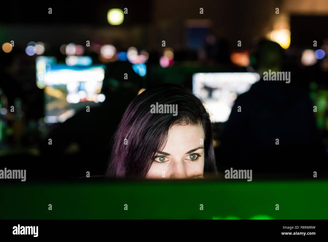 Thun, Switzerland. 10th Dec, 2015. A concentrated female computer game player, dimly lit only by her computer screen at NetGame, Switzerland's largest computer game convention at Thun's expo centre. For 3 days and nights, competing fans and clans play tournaments in CS:GO, Age of Empires and many more. Credit:  Erik Tham/Alamy Live News Stock Photo