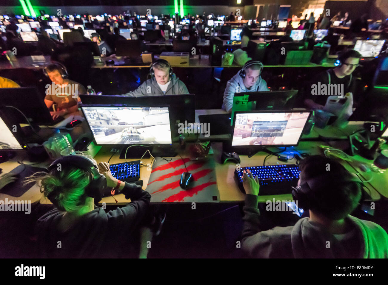 Thun, Switzerland. 10th Dec, 2015. Long rows of concentrated computer game players, dimly lit by their computer screens at NetGame, Switzerland's largest computer game convention at Thun's expo centre. For 3 days and nights, competing fans and clans play tournaments in CS:GO, Age of Empires and many more. Credit:  Erik Tham/Alamy Live News Stock Photo