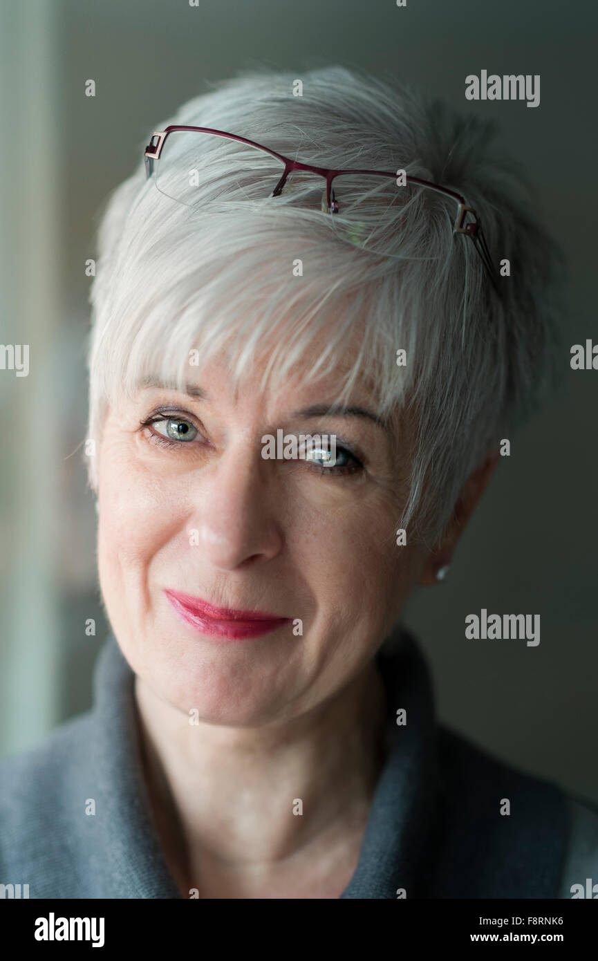 Senior woman with gray hair and glasses on her forehead, smiling, portrait, Germany Stock Photo