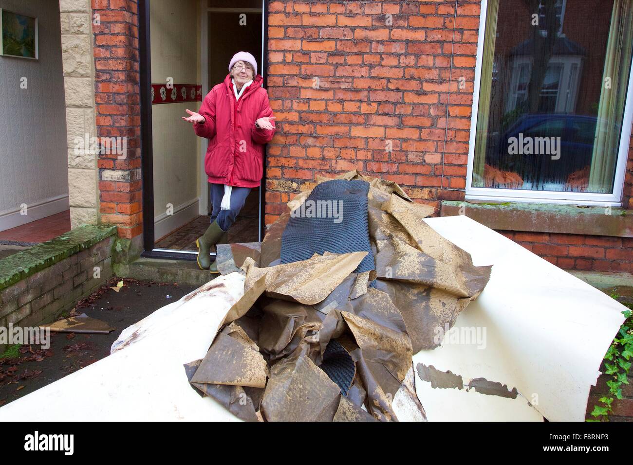 Carlisle, Cumbria, UK. 11th Dec, 2015. Weather and flood damage. Woman standing with her flood damaged furniture. Storm Desmond caused severe flooding in Carlisle and across Cumbria. Carlisle, Cumbria, England, UK. Credit:  Andrew Findlay/Alamy Live News Stock Photo