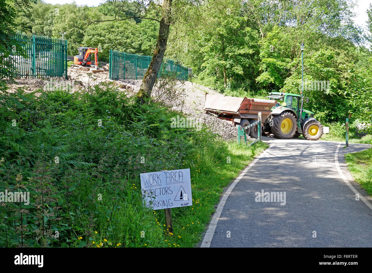 A sign saying work area tractors working with a tractor and trailer in