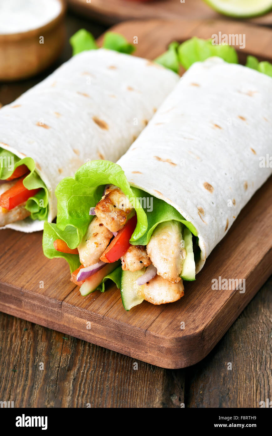 Tortilla wraps on cutting board on wooden table Stock Photo Alamy