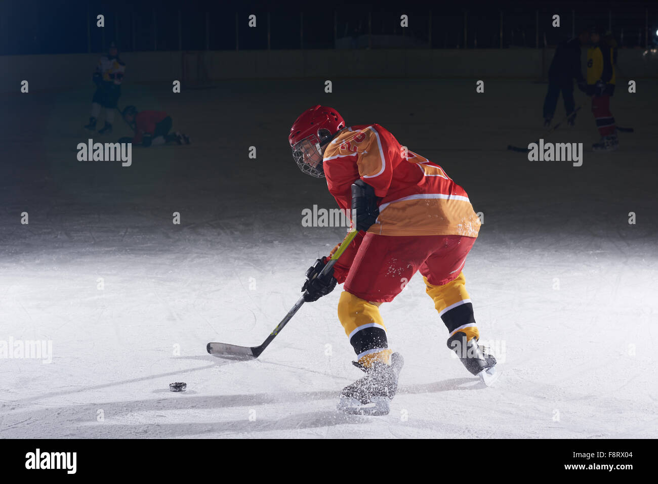 teen girl children ice hockey player in action kicking puck with stick