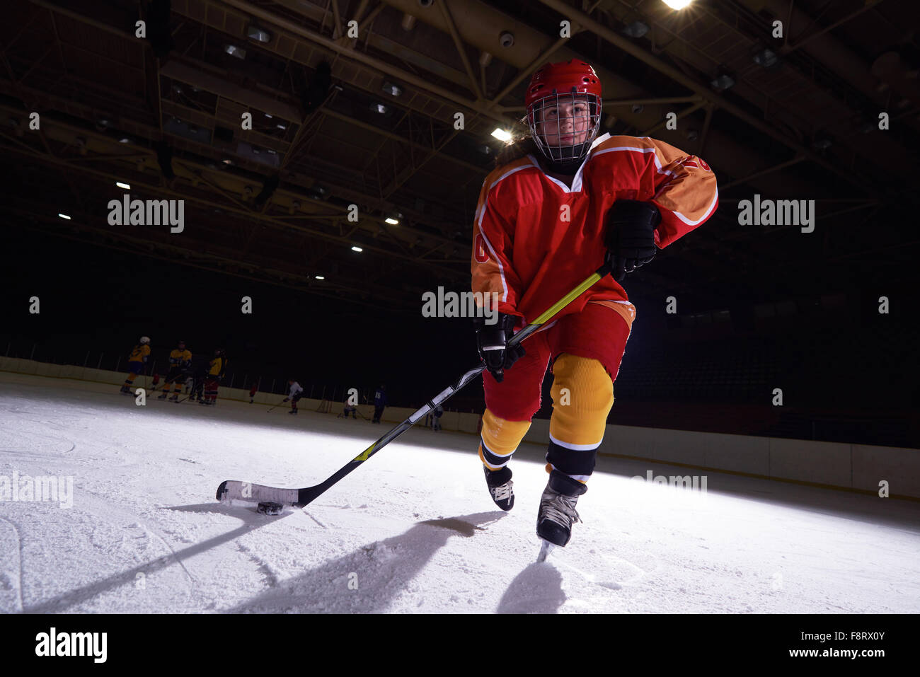 teen girl children ice hockey player in action kicking puck with stick