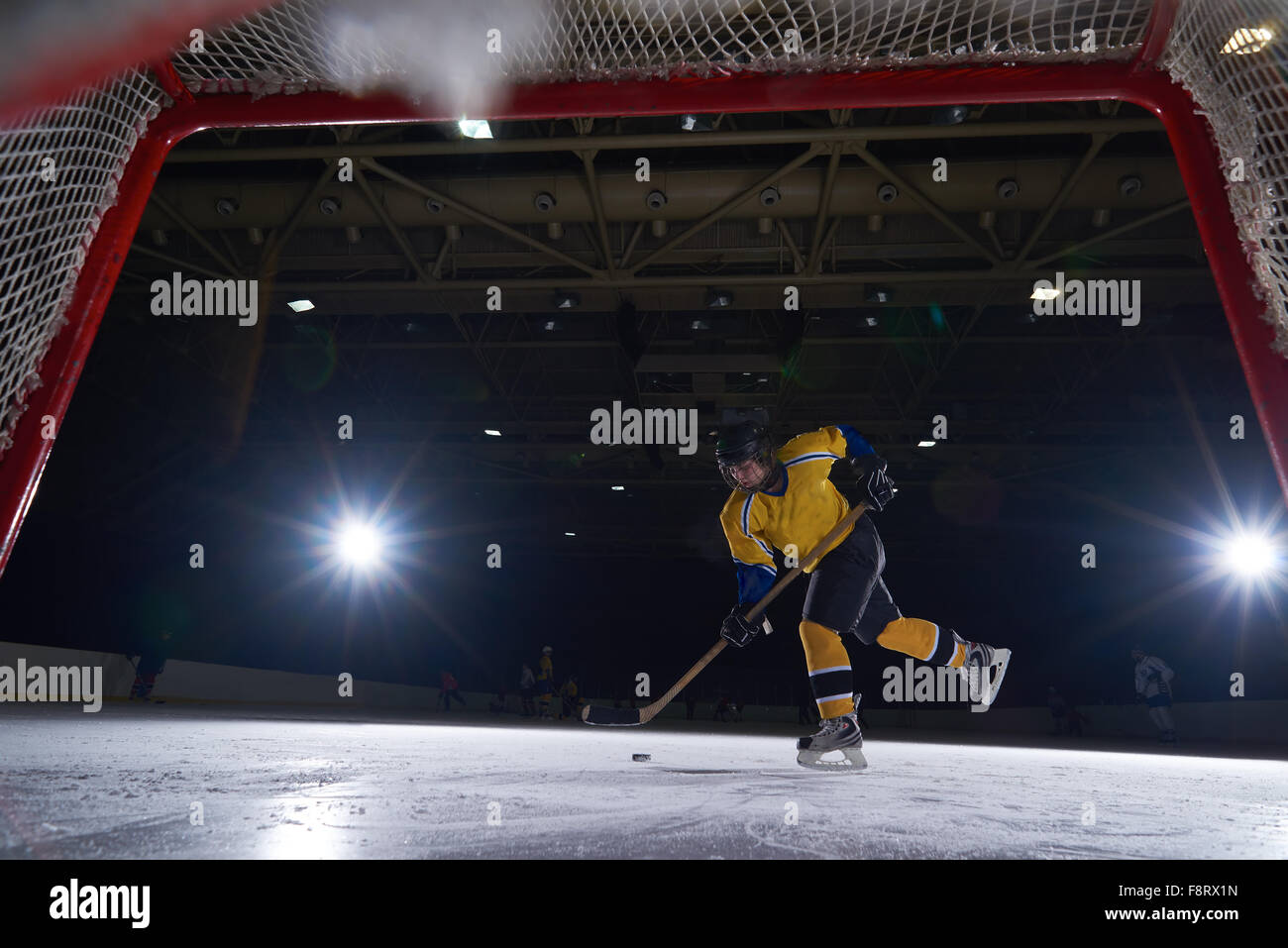 teen girl children ice hockey player in action kicking puck with stick