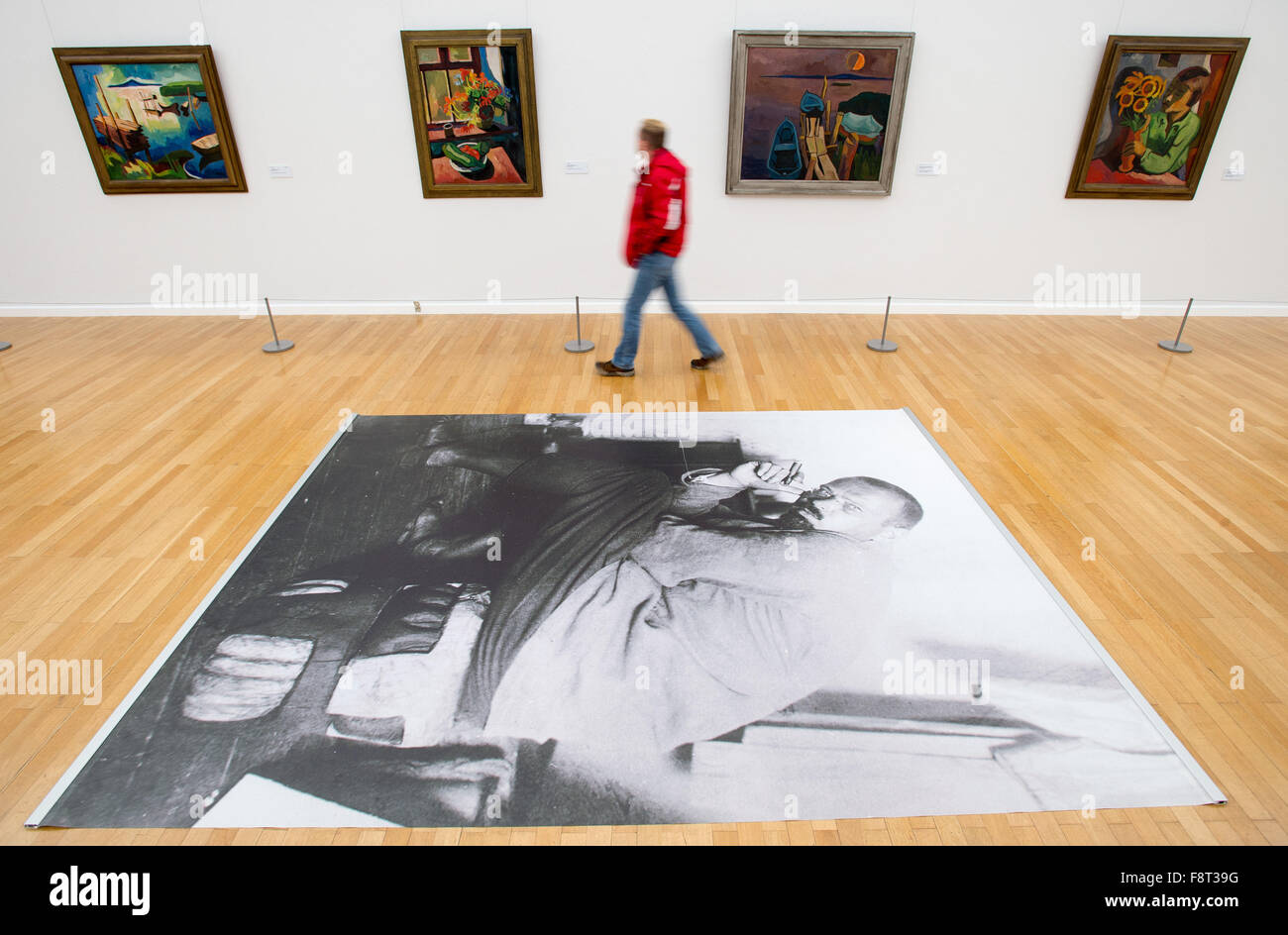 Chemnitz, Germany. 11th Dec, 2015. A man looks at a painting from the artist Karl Schmidt-Rottluff (1884-1976) at the exhibition 'Karl Schmidt-Rottluff - 490 works in the Kunstsammlungen Chemnitz' in Chemnitz, Germany, 11 December 2015. On the ground a blown up black and white photo of the artist can be seen. Works by the artist will be on show from 13 December 2015 until 10 April 2016. Photo: PETER ENDIG/DPA/Alamy Live News Stock Photo