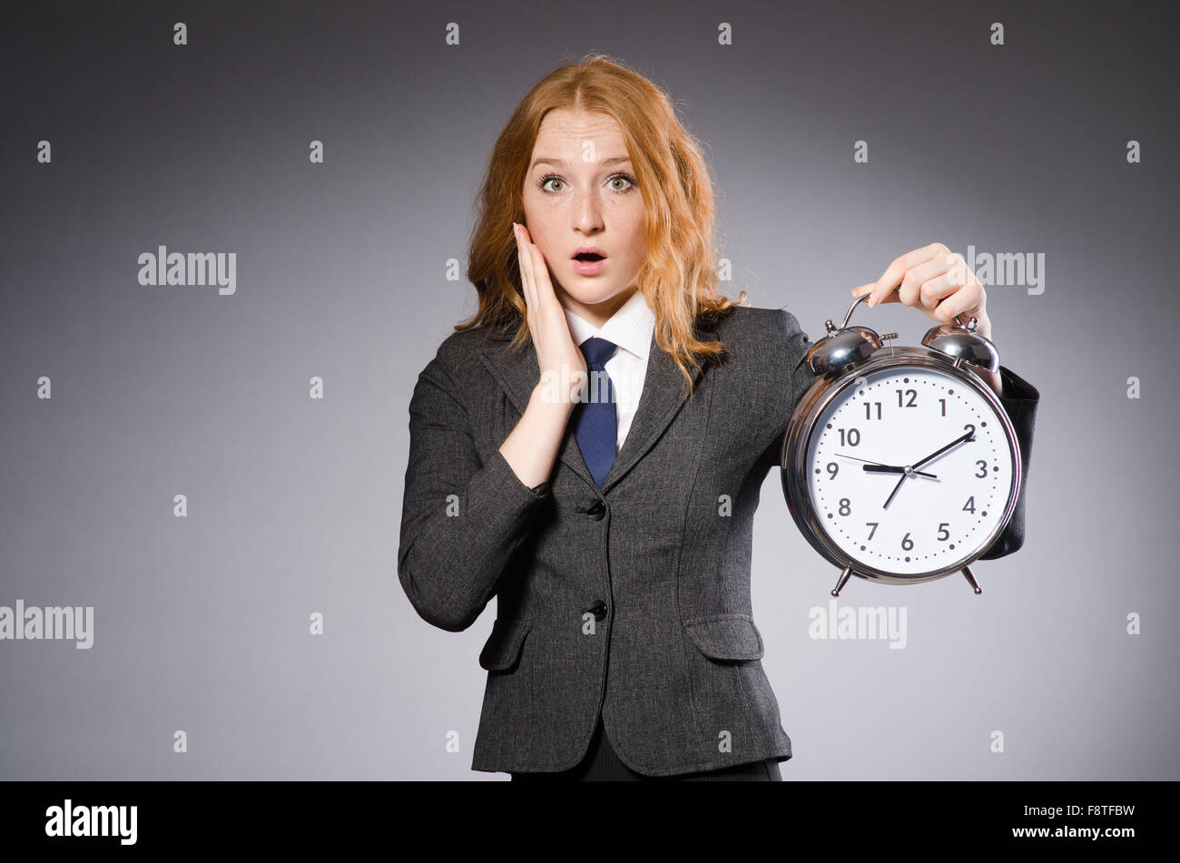 Businesswoman with clock being late for her deliverables Stock Photo
