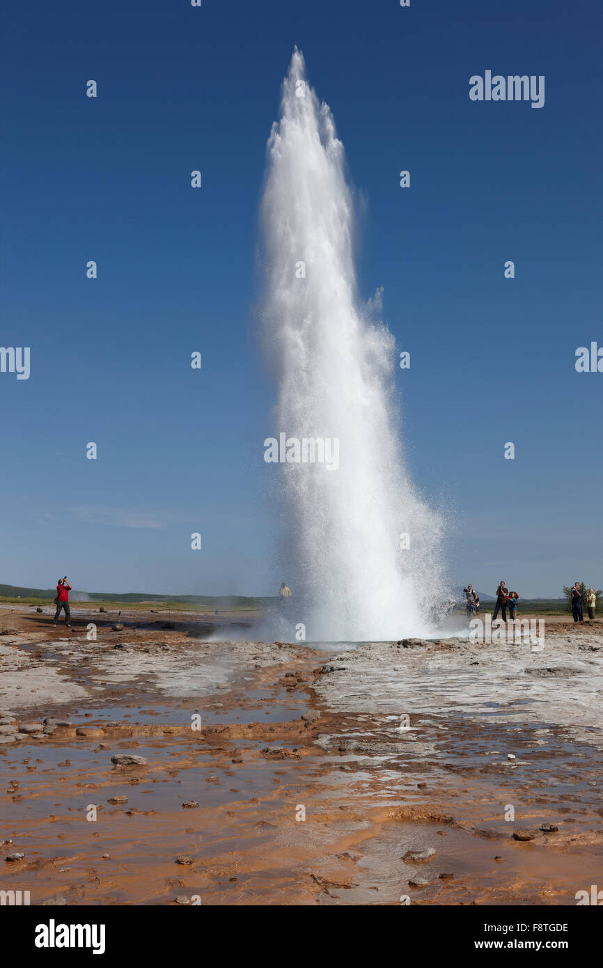 Geyser Strokkur against blue summer sky, erupting hot water and steam ...