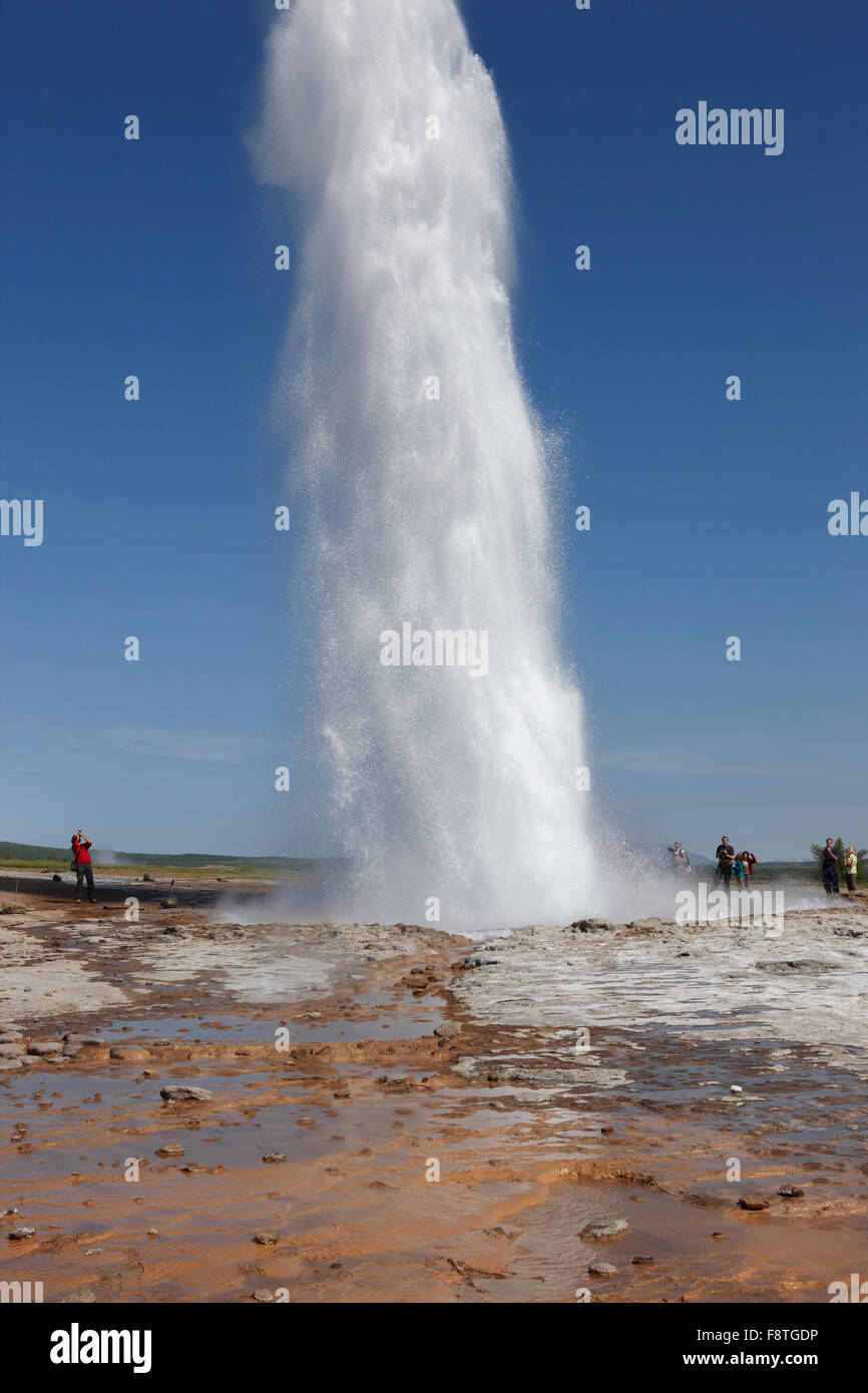 Geyser Strokkur against blue summer sky, erupting hot water and steam ...