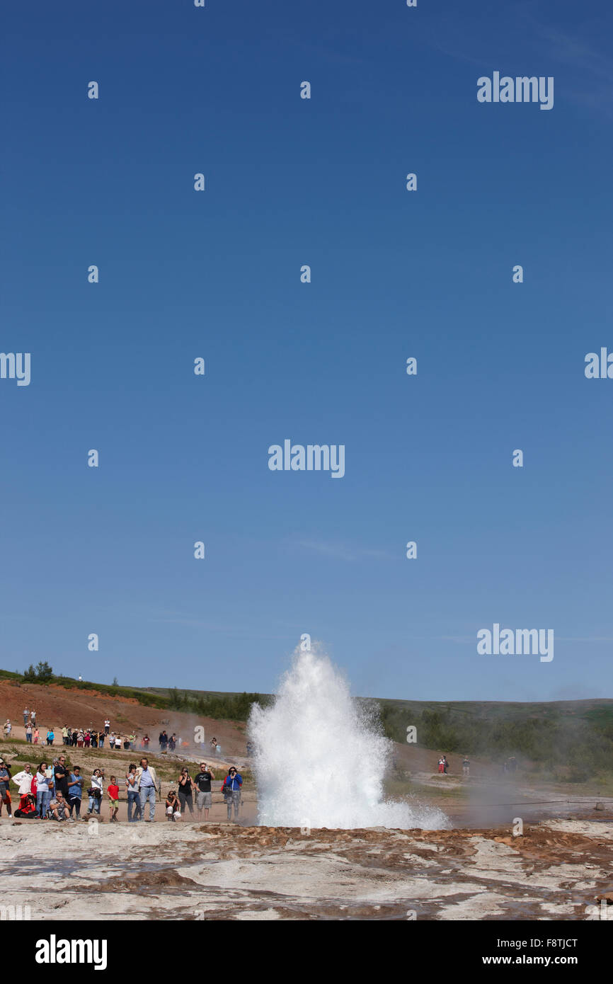 Geyser Strokkur against blue summer sky, erupting hot water and steam ...