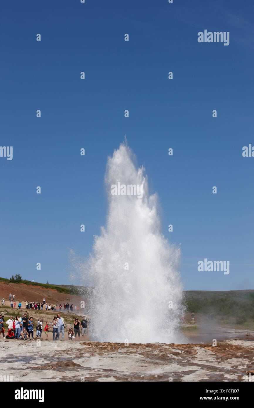 Geyser Strokkur against blue summer sky, erupting hot water and steam ...