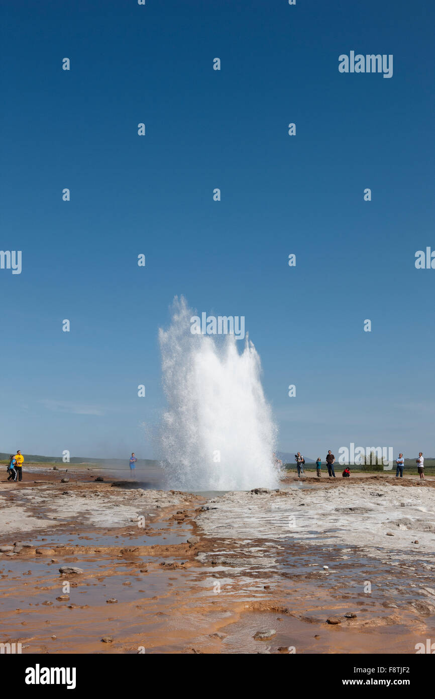 Geyser Strokkur against blue summer sky, erupting hot water and steam ...