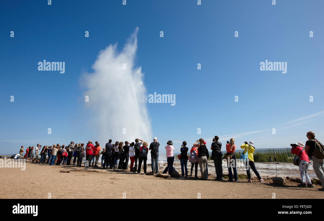 Geyser Strokkur with tourists against blue summer sky, erupting hot ...