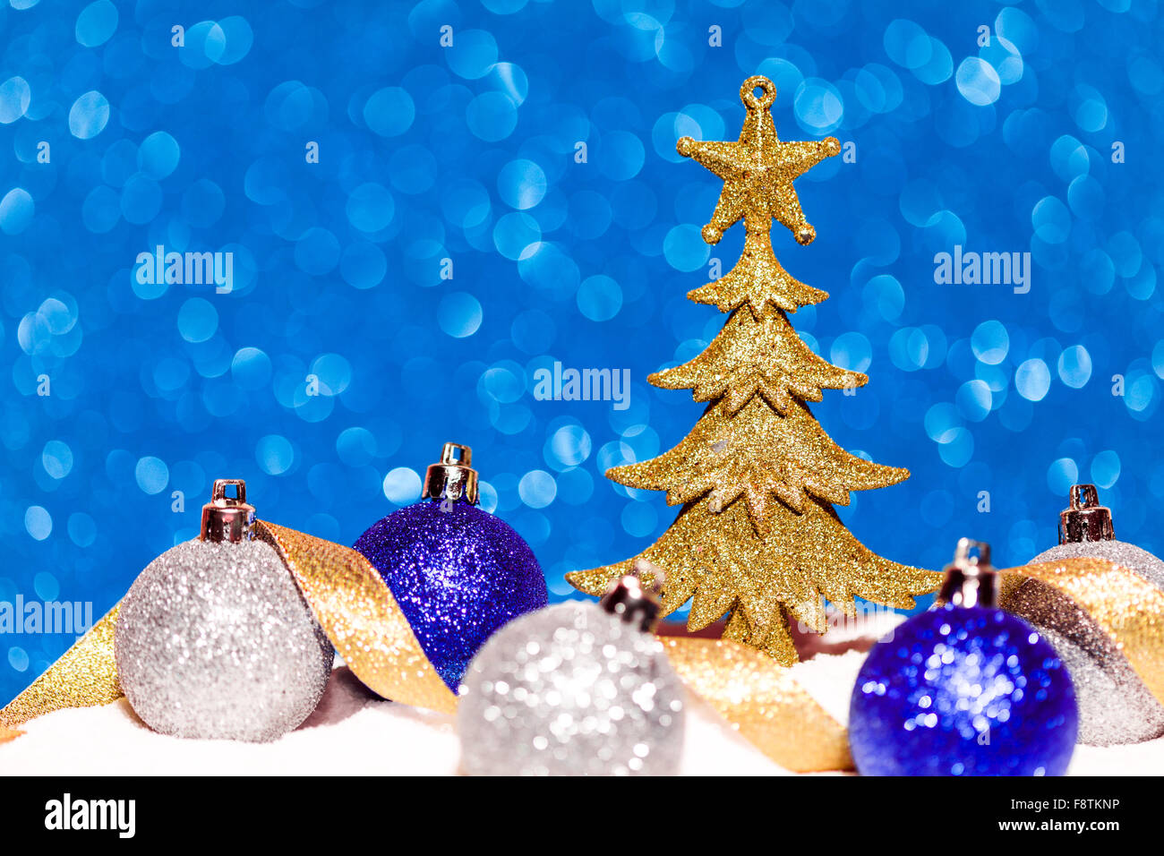 Golden Christmas tree on glitter blue background Stock Photo - Alamy