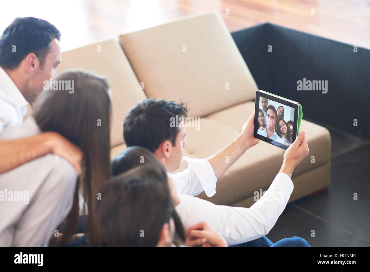 group of friends taking selfie photo with tablet at modern home indoors ...