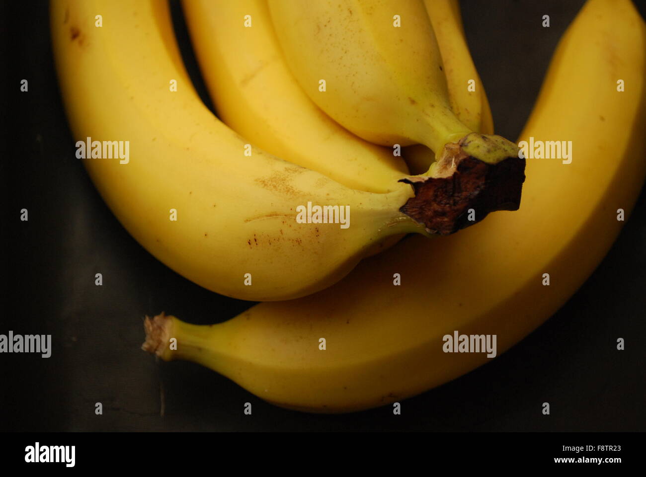 Bananas On Black Stock Photo - Alamy