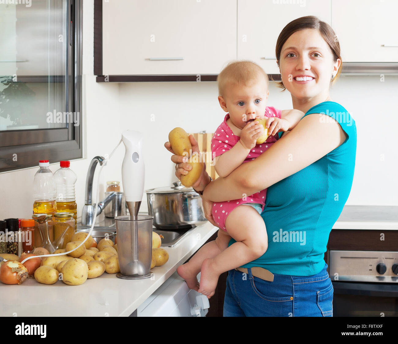 Happy mother and child  with blender in kitchen at home Stock Photo