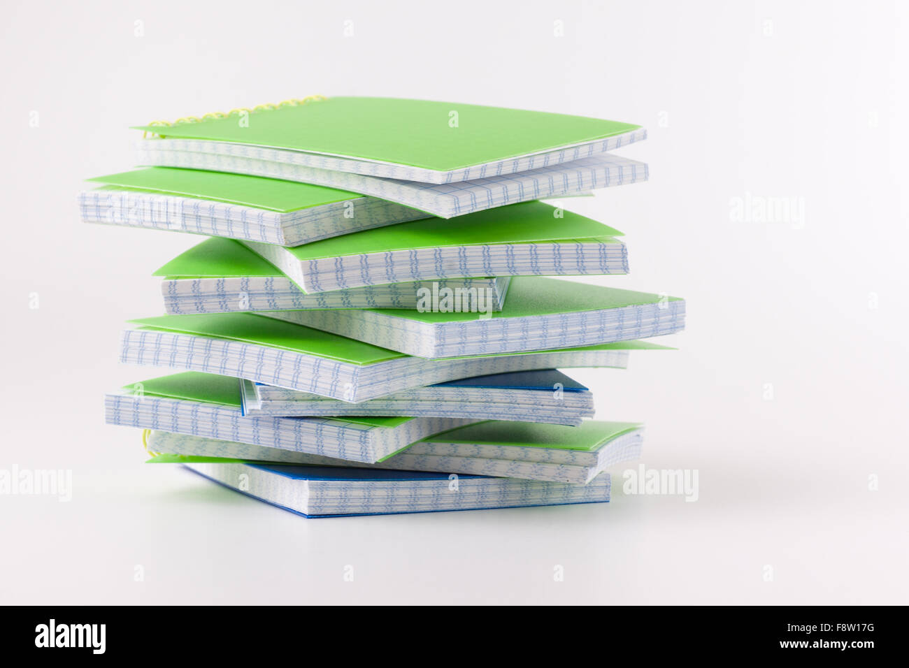the pile of green notepads lies on a white background Stock Photo