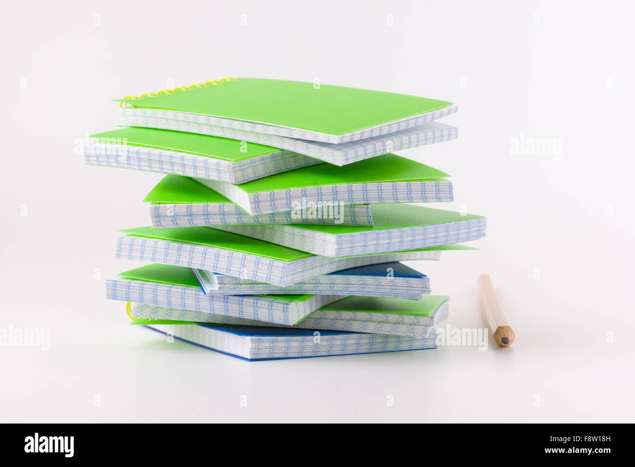 the pile of  notepads lies on a white background with a pencil Stock Photo
