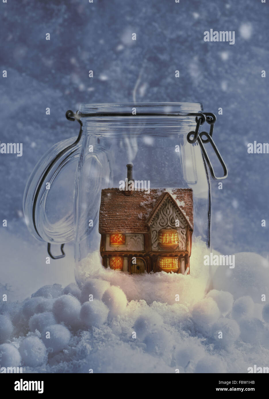 Cosy country cottage in snow filled glass jar at night Stock Photo