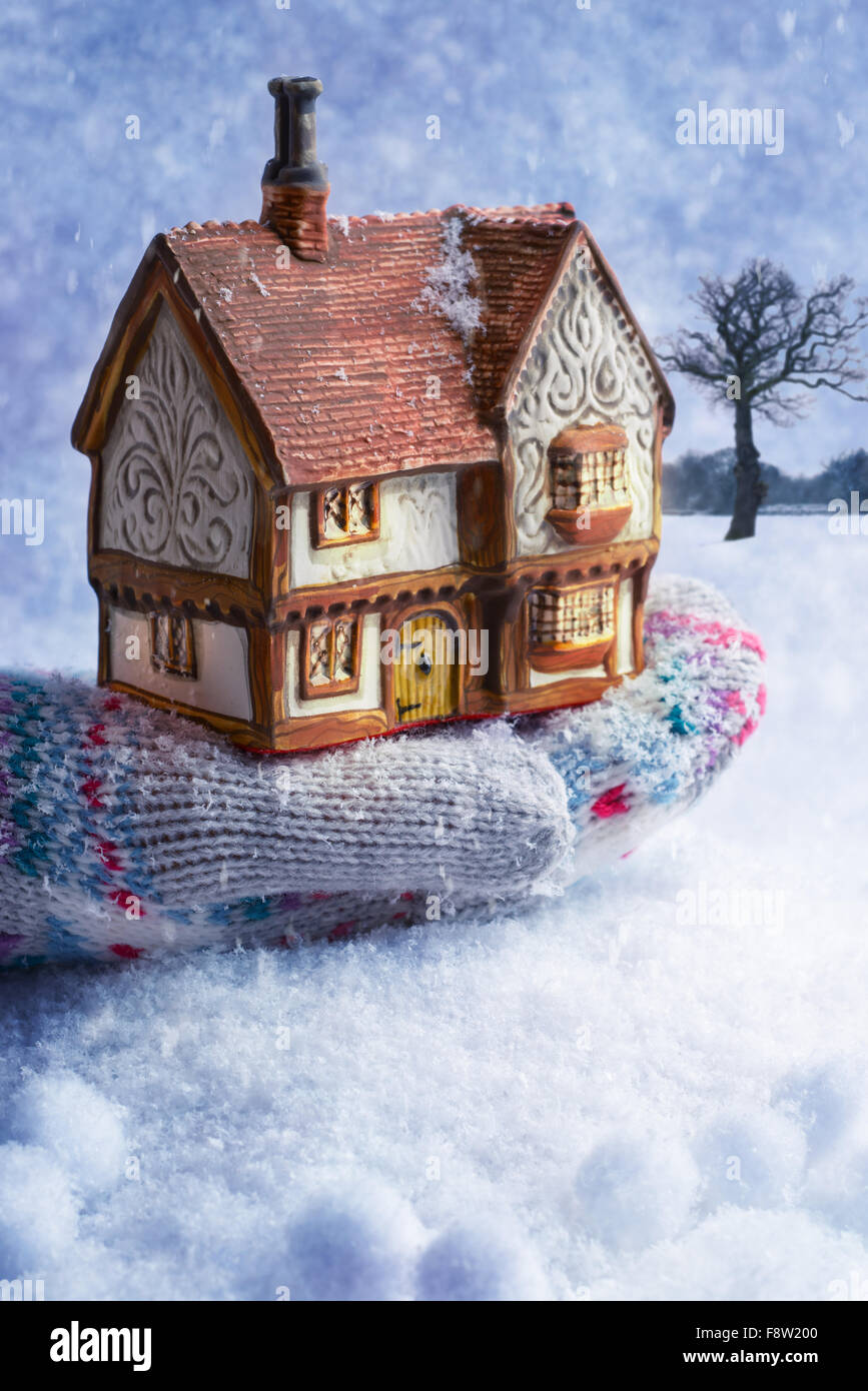 Winter cottage in gloved hand with snow Stock Photo