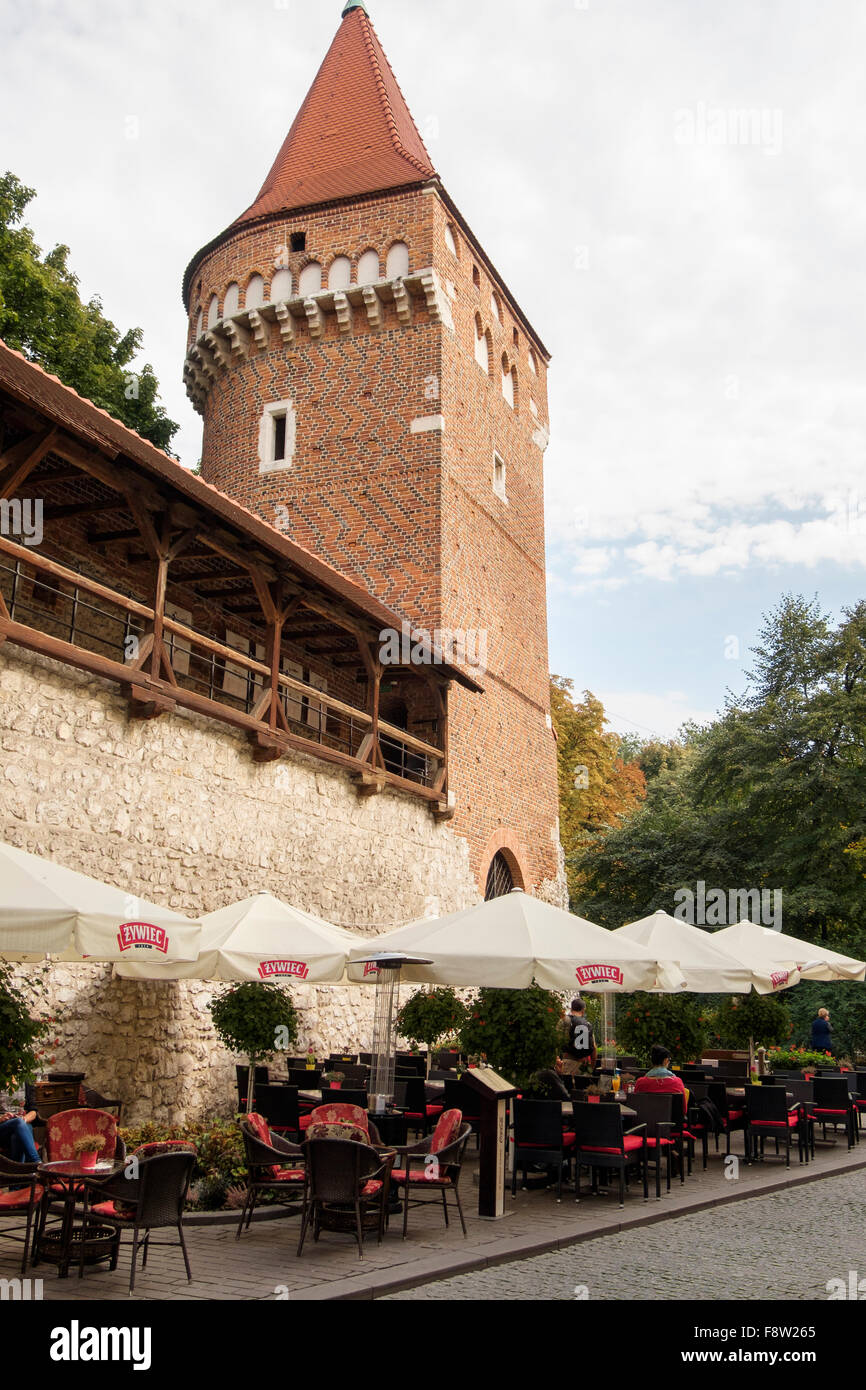 Street cafe below Tower in old town walls with covered walkway. Krakow, Poland, Europe Stock Photo