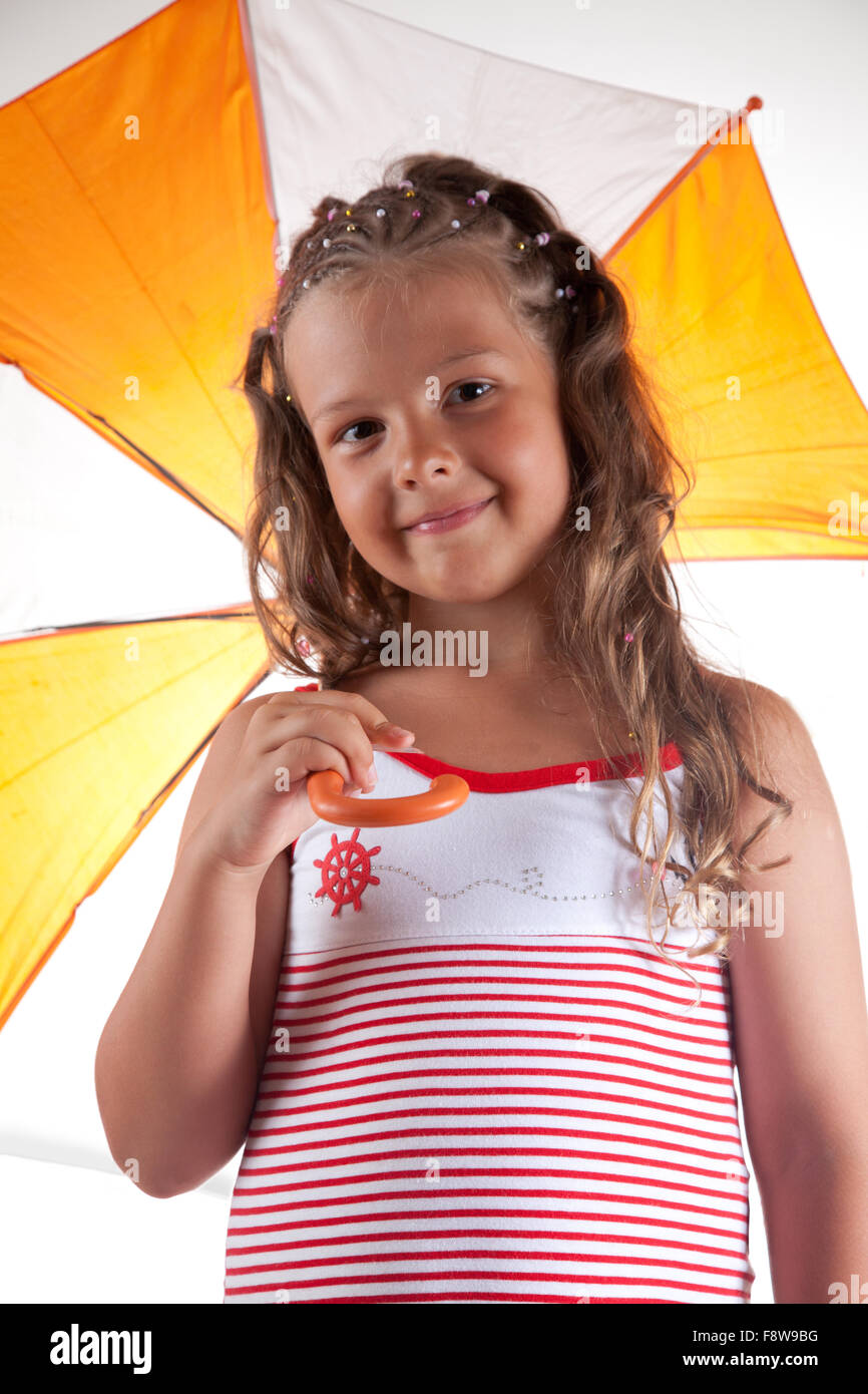 Little girl wearing summer dress and holding umbrella Stock Photo