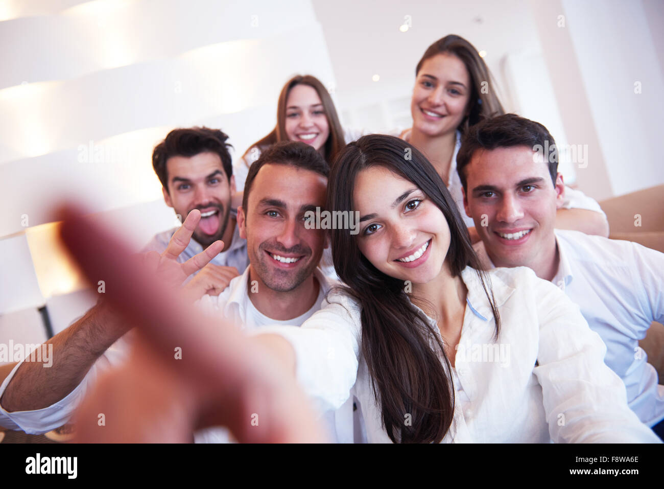 group of friends taking selfie photo with tablet at modern home indoors ...
