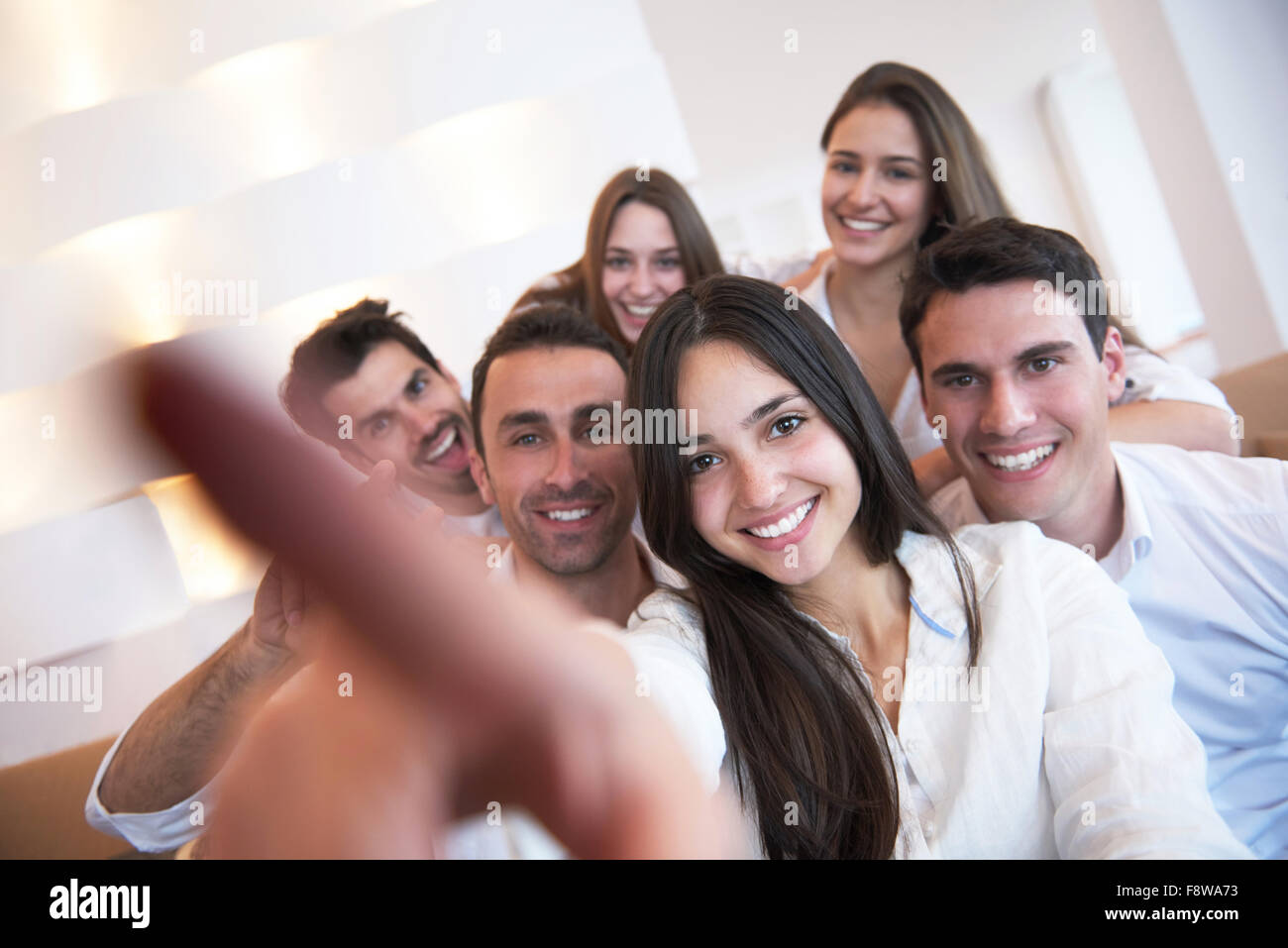 group of friends taking selfie photo with tablet at modern home indoors ...