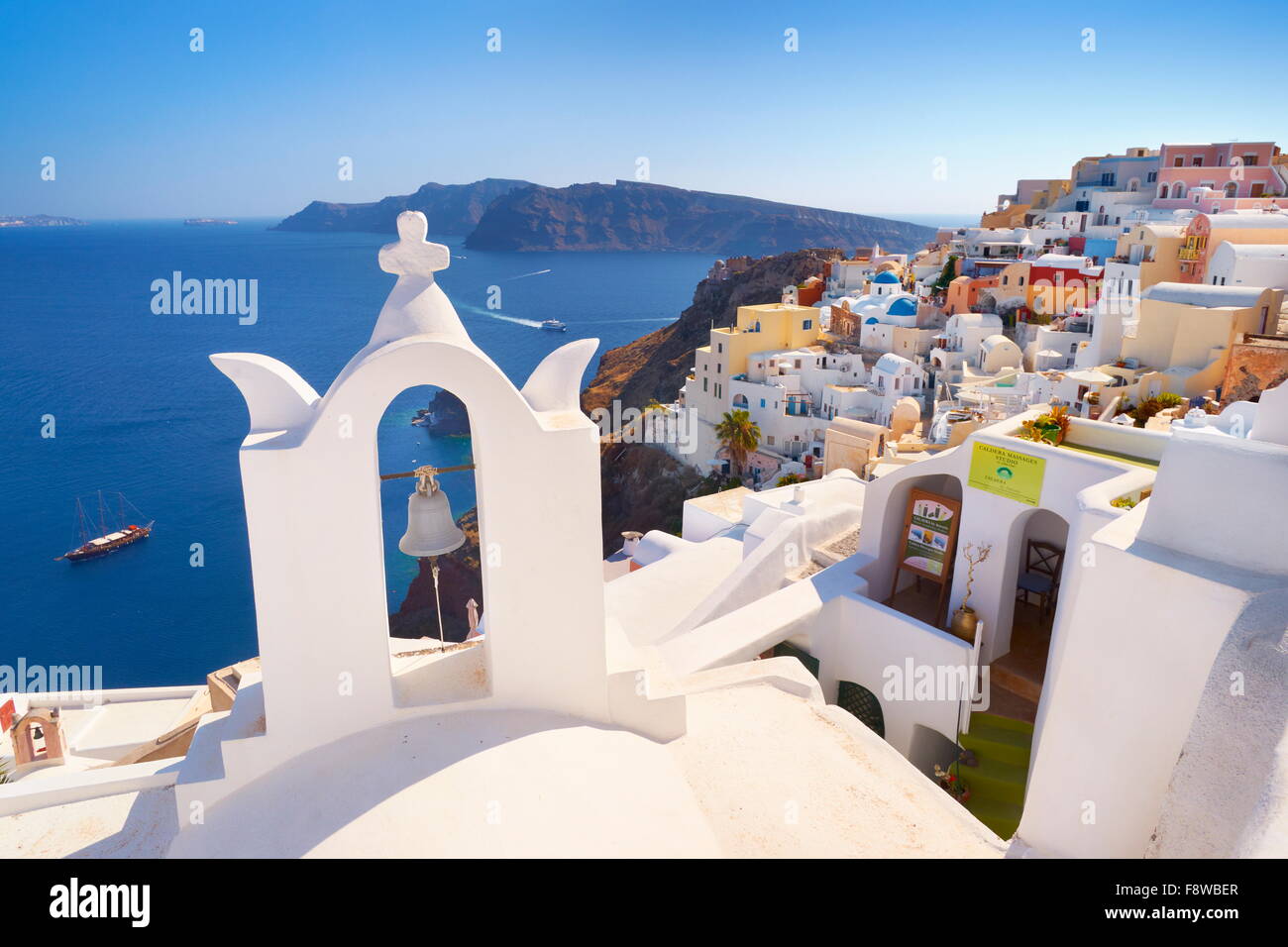 Santorini landscape with white greek bell tower and sea in the background - Oia Town, Santorini Island, Cyclades, Greece Stock Photo