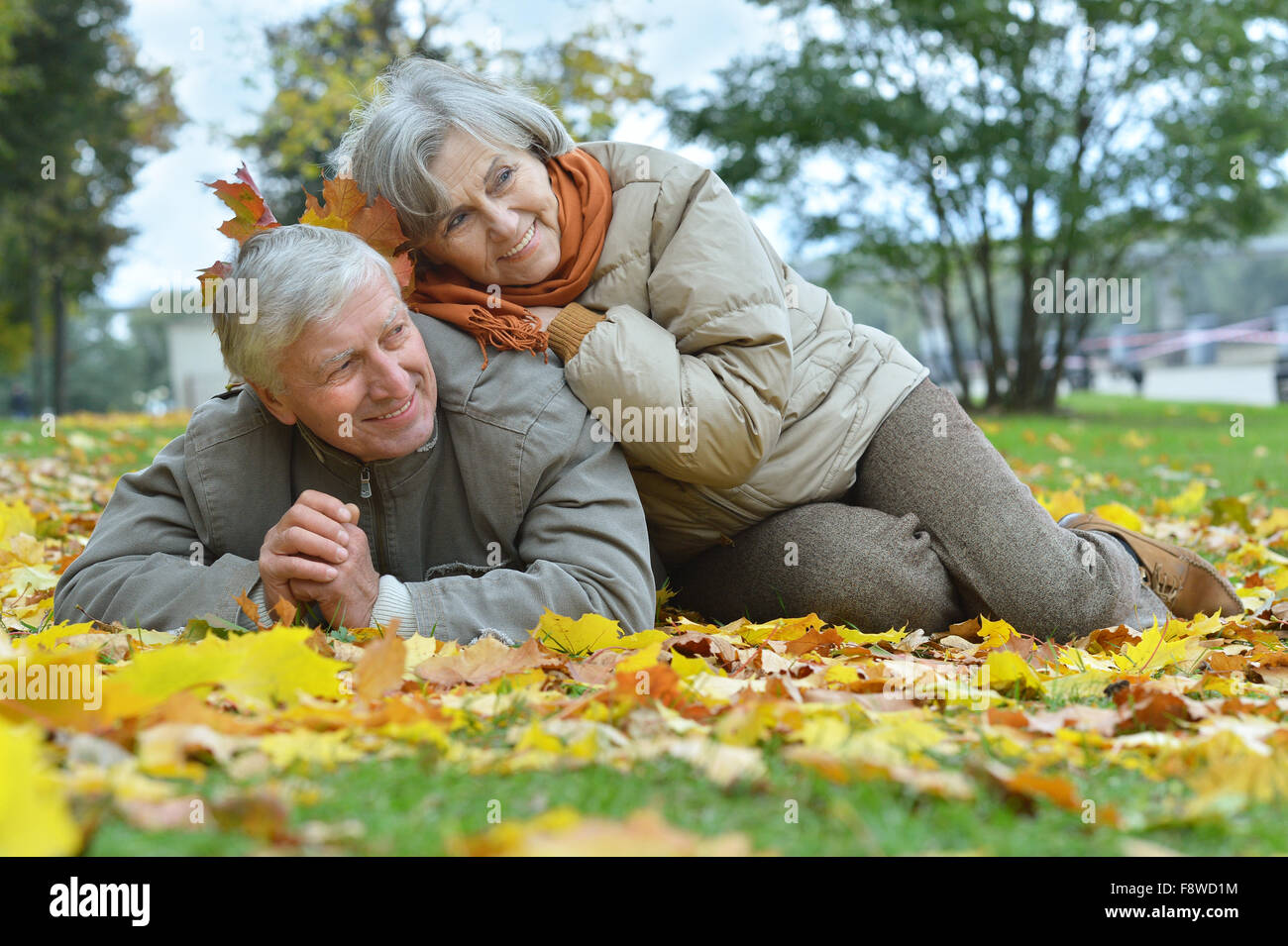 Elderly couple sitting in autumn nature Stock Photo