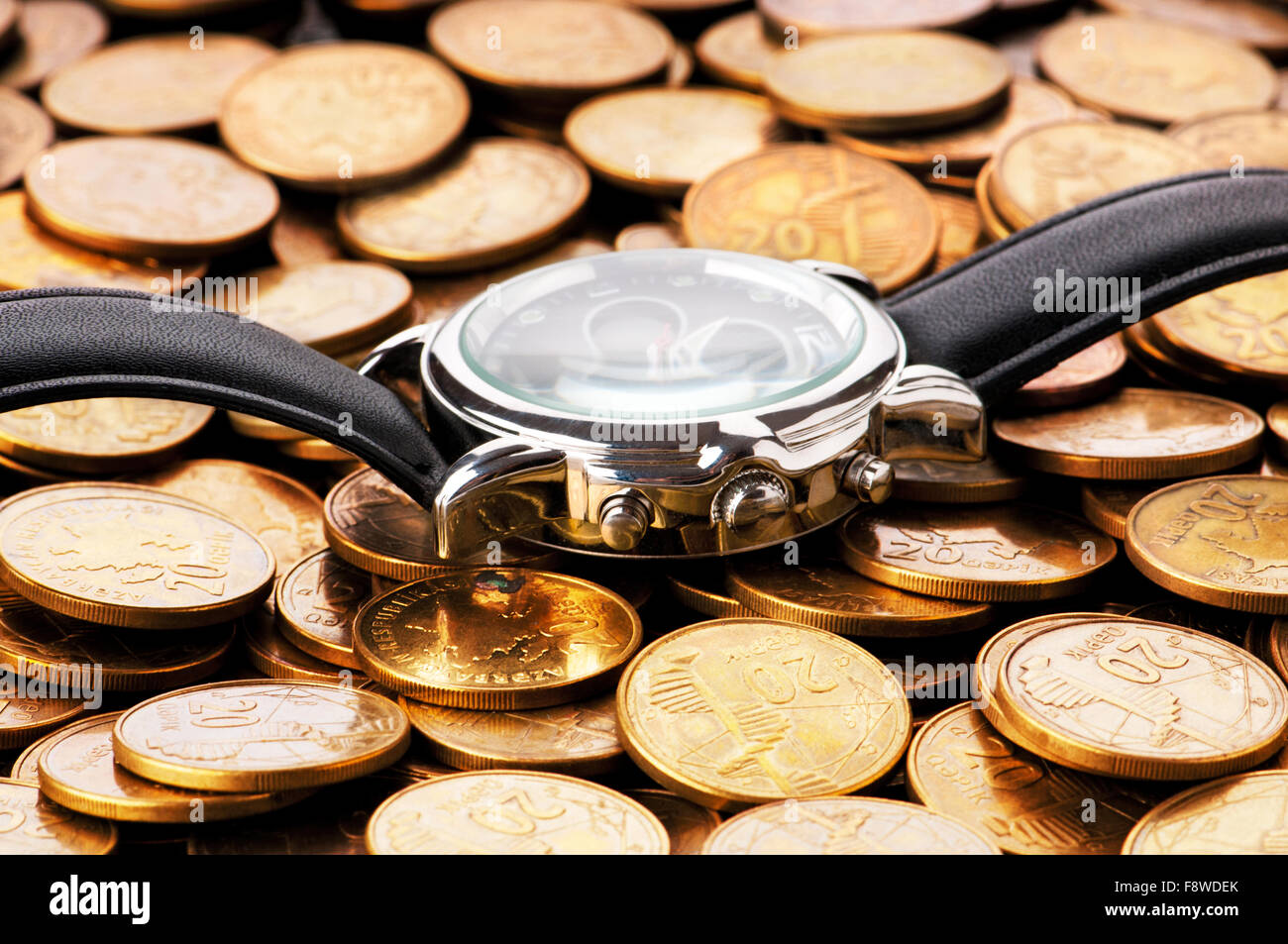 Time is money concept with watch and coins Stock Photo - Alamy