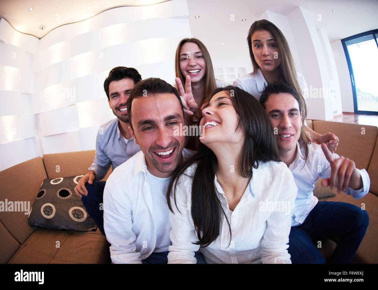 group of friends taking selfie photo with tablet at modern home indoors ...