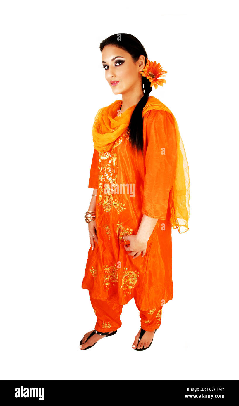 A very pretty east indian teenage girl standing in her traditional indian dress with a flower in her long black hair for white b Stock Photo