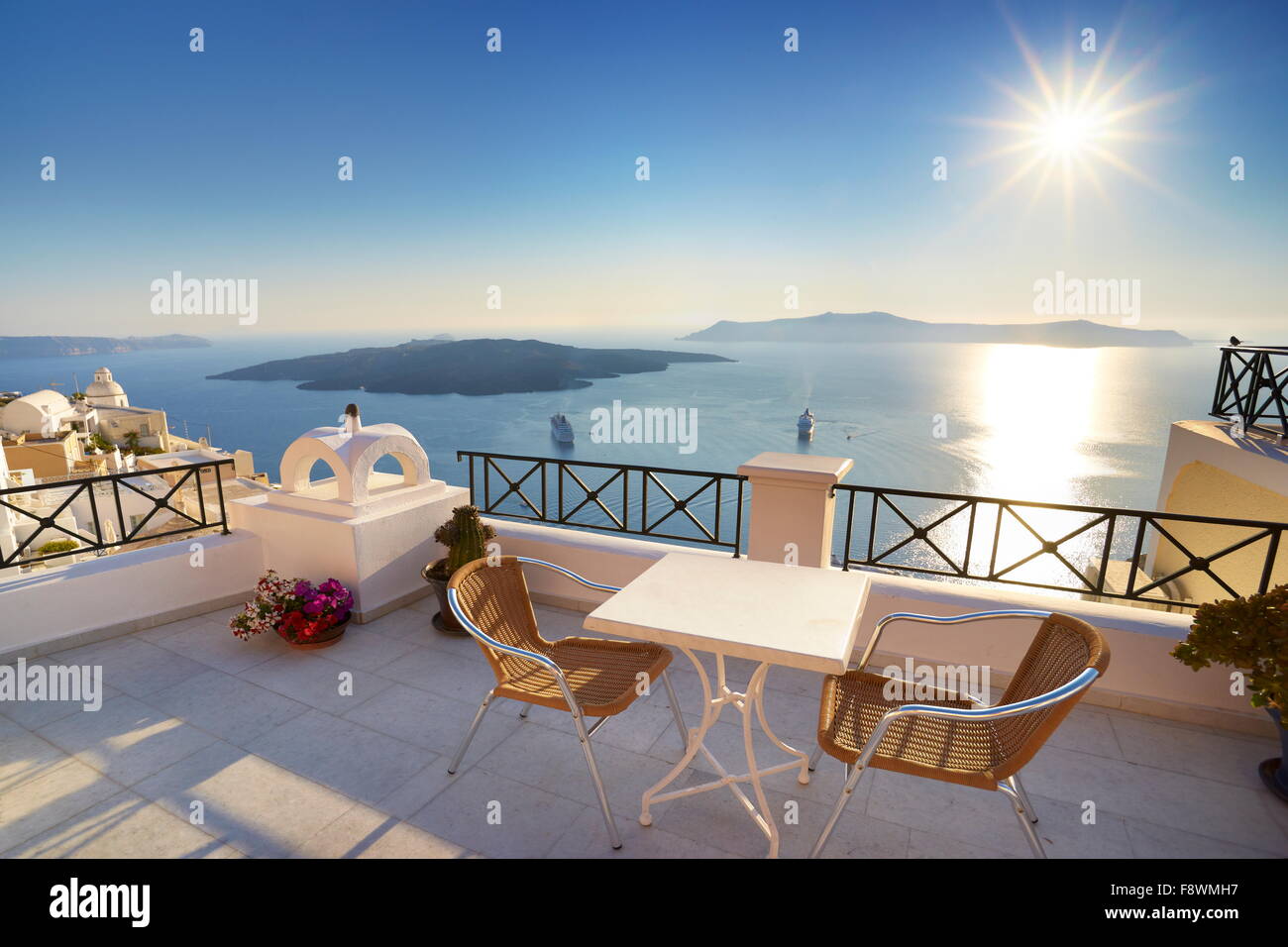 Thira (capital city of Santorini) - terrace with a background view to the sea and sun on the sky, Santorini Island,  Greece Stock Photo