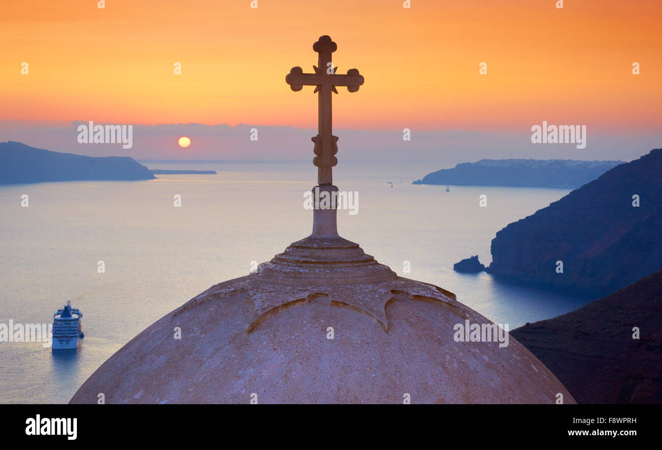 Santorini, Greece - view at church with cross on the top at sunset time in Thira (capital city of Santorini) Stock Photo