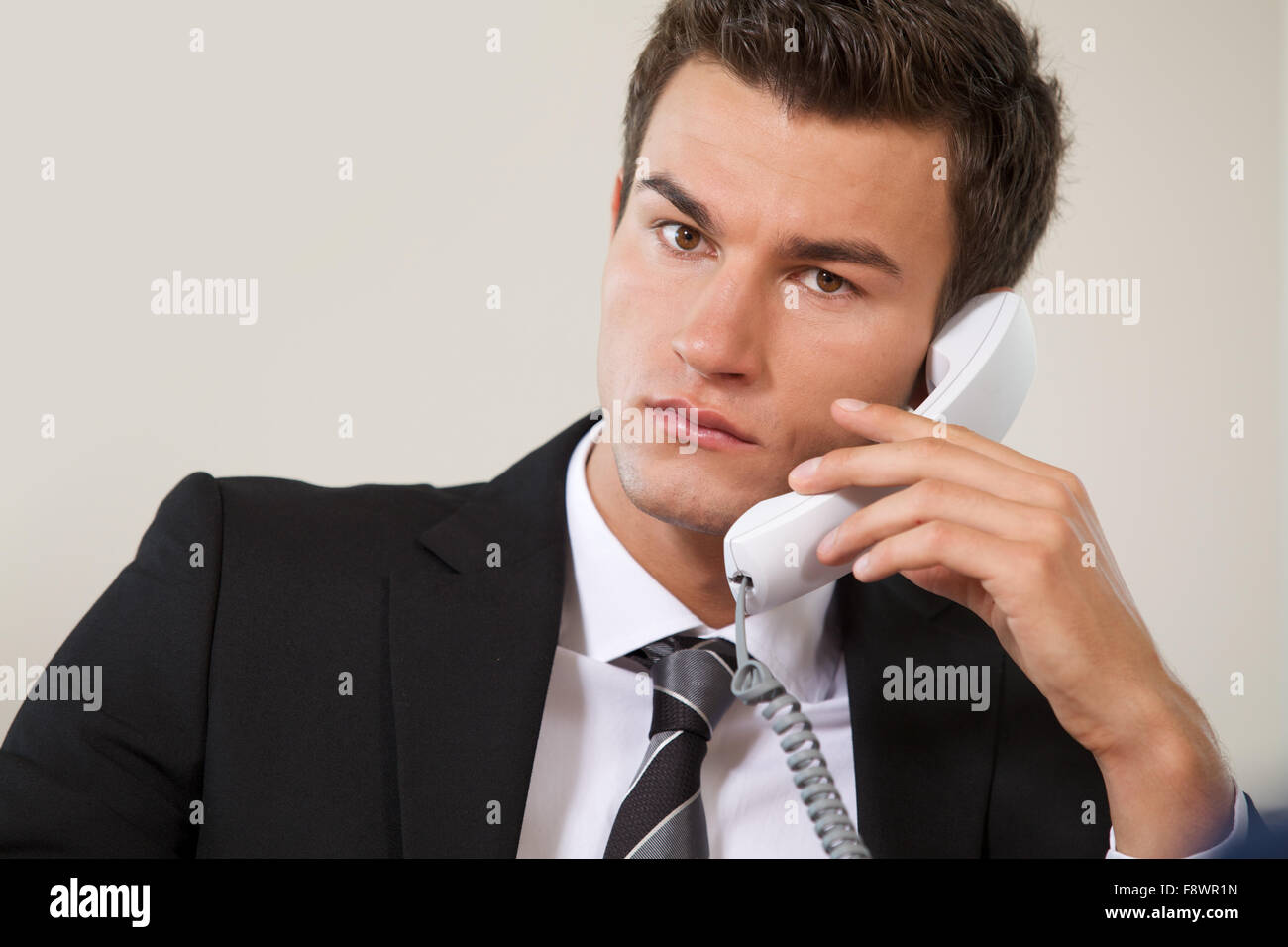 Portrait of businessman conversing on landline phone Stock Photo - Alamy