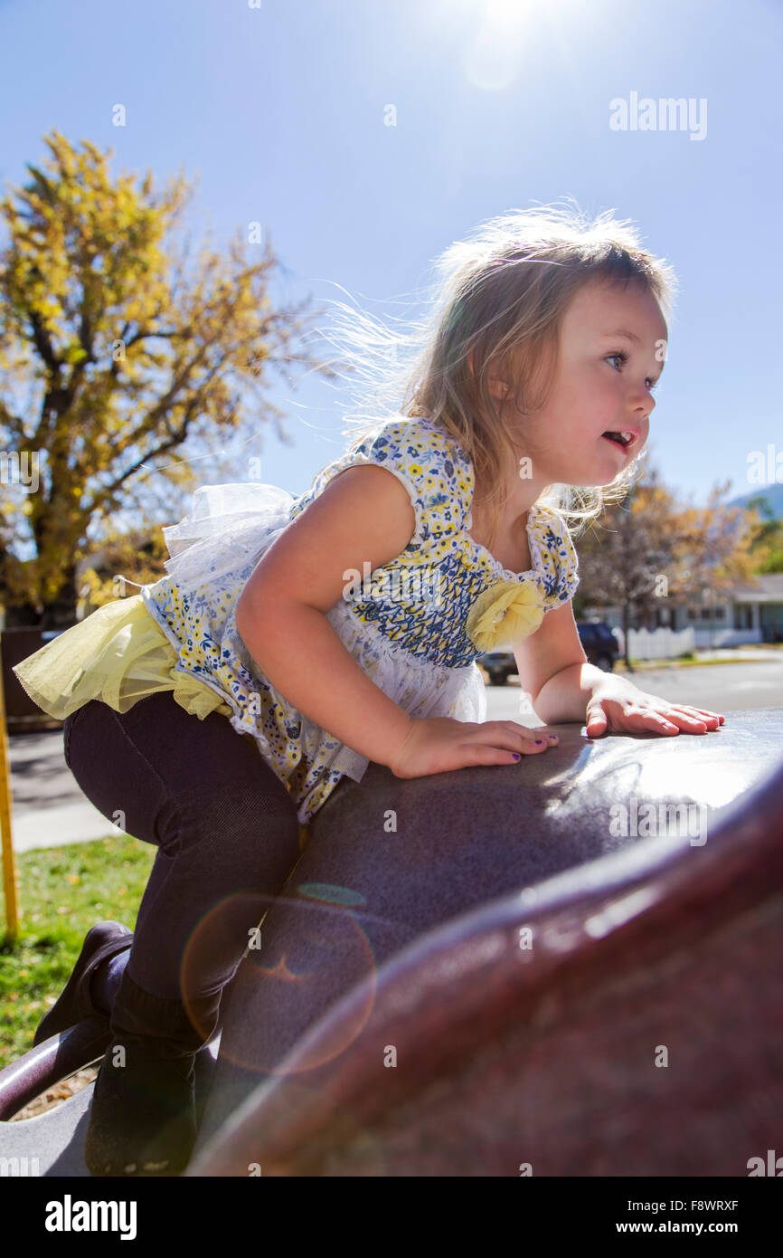 Four year old little girl playing outside on a jungle gym in a park Stock Photo