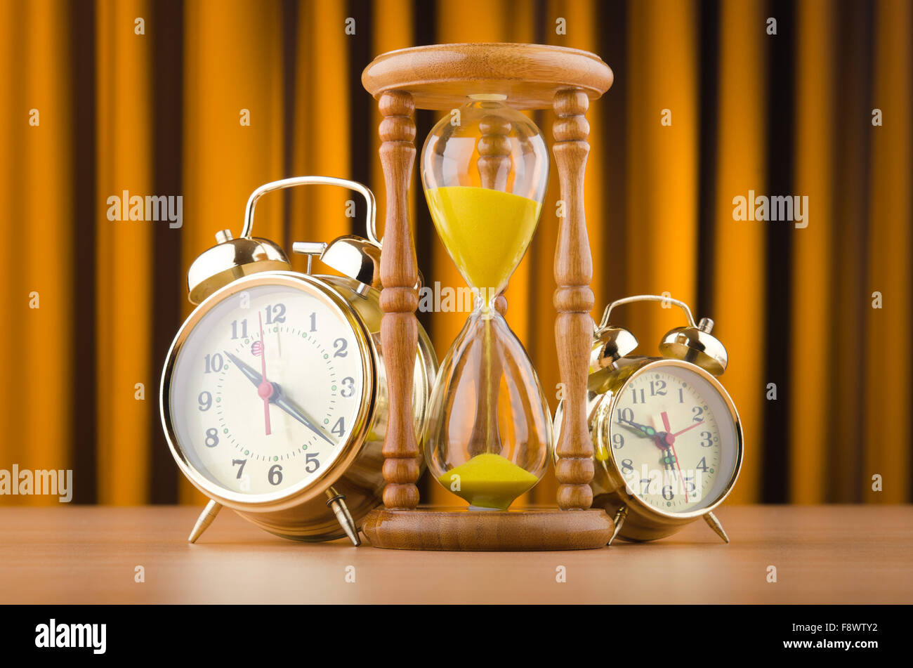 Alarm clocks and hourglass in time concept Stock Photo Alamy