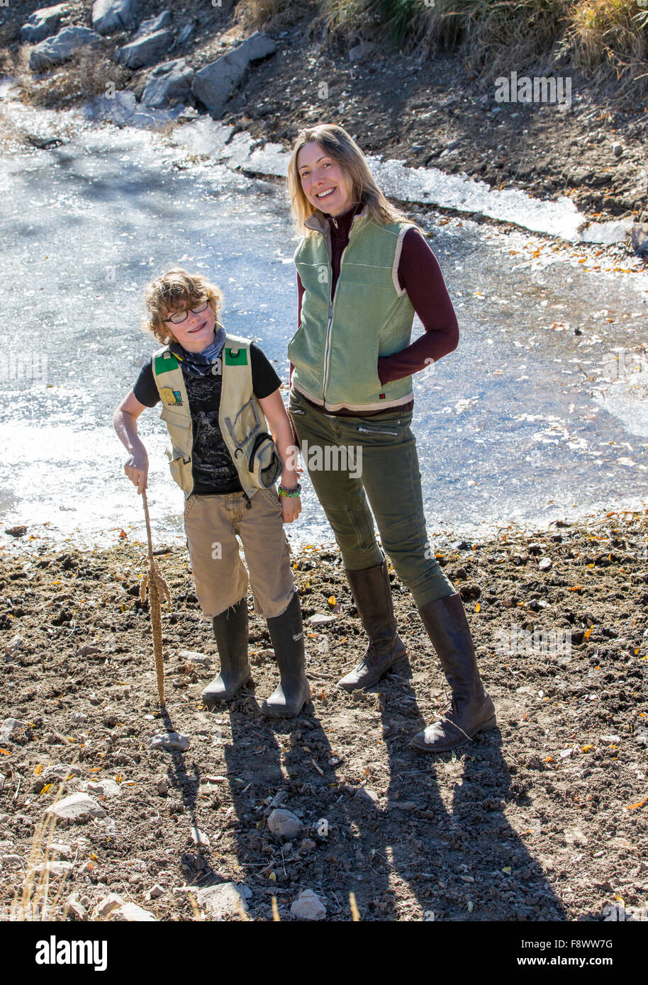 Attractive mother and young son near frozen ranch pond Stock Photo