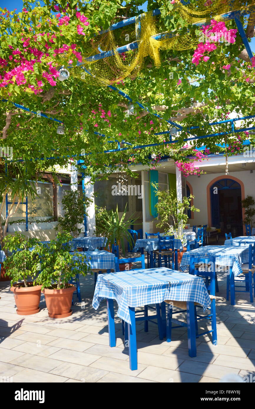 Local restaurant decorated with flowers -  village Kamari,  Santorini Island, Cyclades Islands, Greece Stock Photo